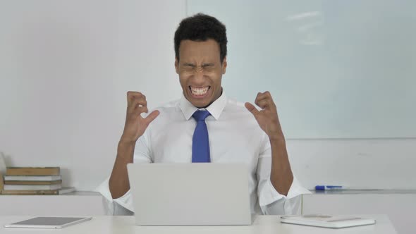 Afro-American Businessman in Anger and Frustration Going Crazy at Work