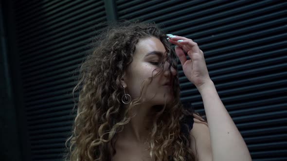 Close-up Portrait of a Beautiful Young Curly-haired Woman Who Is on the Street During the Day and