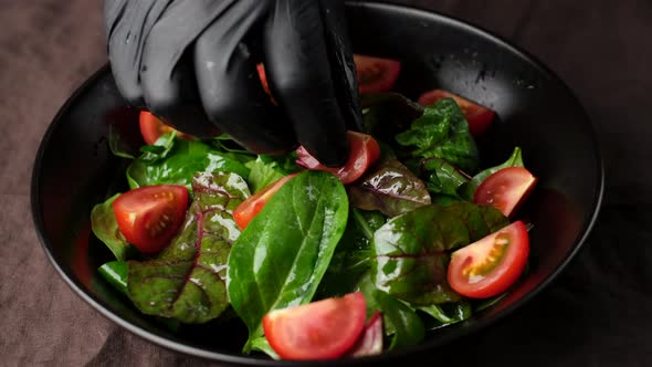 Chef putting tomatoes in salad