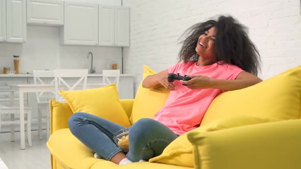 Woman sitting on the couch and playing video game.