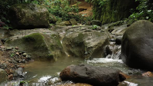 Flying above a stream in the tropics showing the water flowing