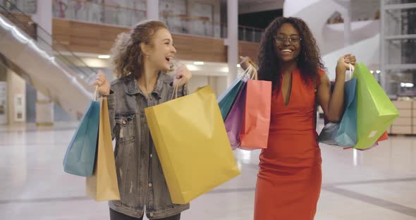 Two Excited Diverse Friends Shopping Together on Black Friday