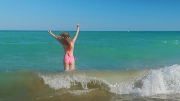 Tall Woman with a Long Hair From a Back is on a Beach