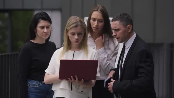 Young Woman Using Laptop with Colleagues Getting Bad News About Ebusiness