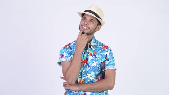 Young Happy Bearded Indian Tourist Man Smiling While Thinking