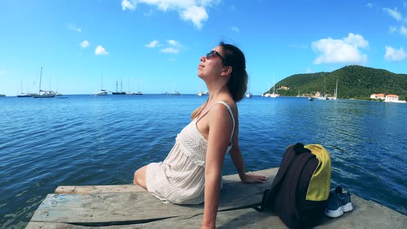 Smiling Woman Enjoys Her Vacation Sitting Near Ocean
