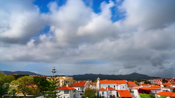 Suburb Houses and Silhouettes of Mountain Under Rolling Clouds