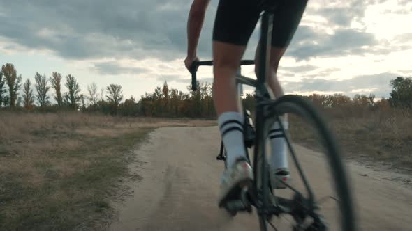 Cycling Athlete Cycling On Trail. Cyclist Twists Pedals And Riding On Gravel Bike.