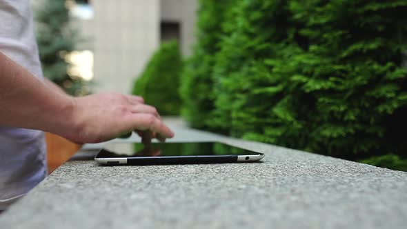 The man is typing on a tablet