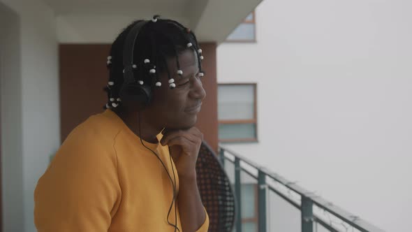 Portrait of African American Black Man with Dreadlocks Listening To the Music on the Balcony