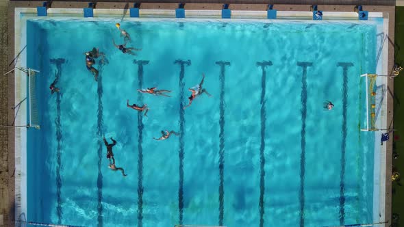 Aerial Drone Top View Shot of People Competing in Water Polo in Turquoise Water Pool