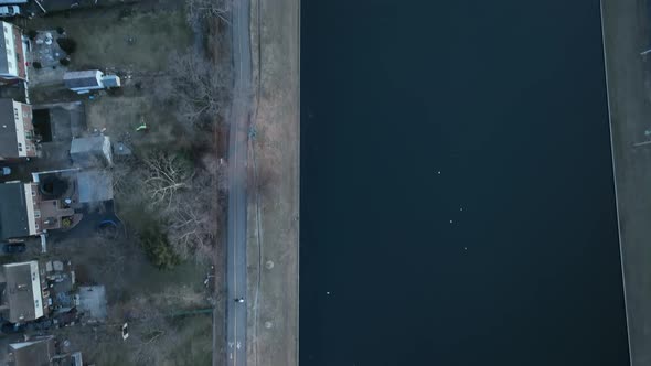 An aerial shot directly above a green pond in a suburban neighborhood on Long Island, NY.  The camer