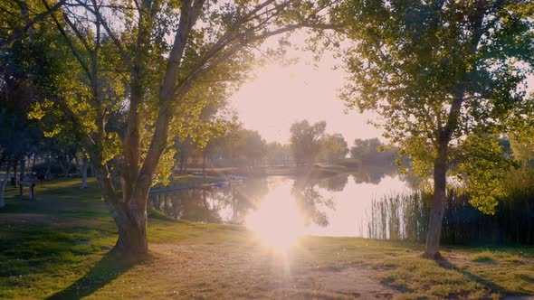 Spectacular aerial parallax of sunrise over park lake on colorful fall morning