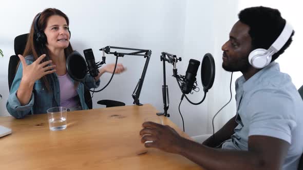 Multiracial people recording a podcast using microphone and laptop from home studio