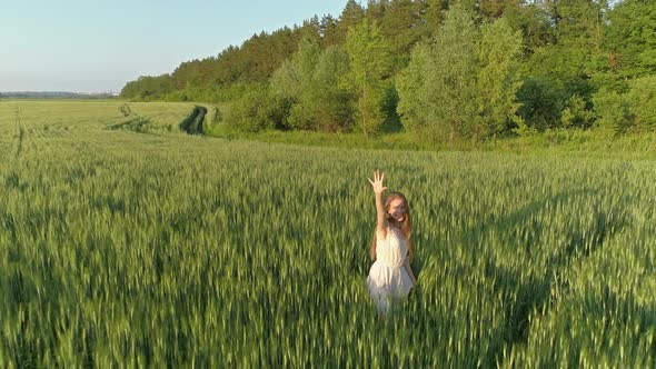 Girl Walking in Wheat Field at Sunset, Aerial View