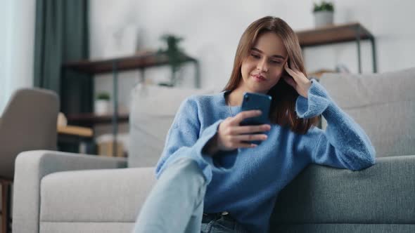 Woman Using Smartphone on Couch