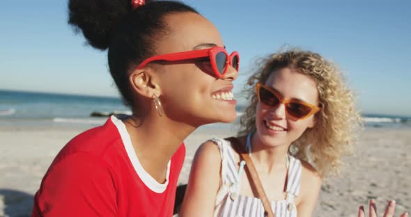 Two young adult female friends having fun at the beach 4k