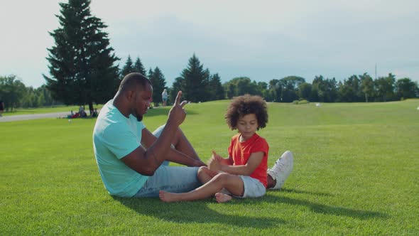 Dad with Little Son Playing Leisure Games Outdoors