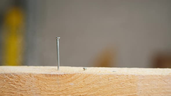 Man Builder Hammering Nails Into Wood Closeup Using Hammer