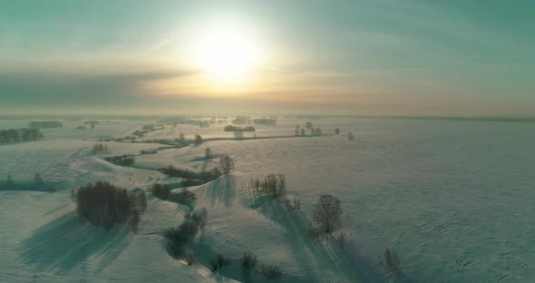 Aerial View of Cold Winter Landscape Arctic Field Trees Covered with Frost Snow Ice River and Sun