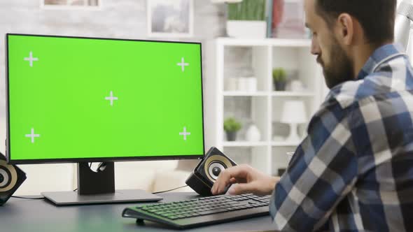 Zoom in Parallax Footage of Young Man Working on PC with Green Screen