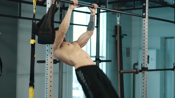 Strongman Trains Abdominal Muscles on Bar in Gym alt