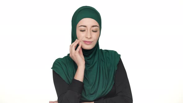 Portrait of Sick Arabic Woman in Hijab Massaging Her Cheek and Suffering From Toothache Over White