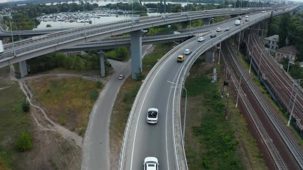 Aerial drone shot of a car driving on a bridge.