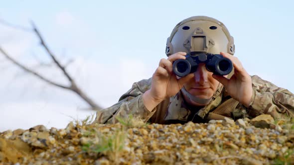 Front view of military soldier looking through binoculars during military training 4k