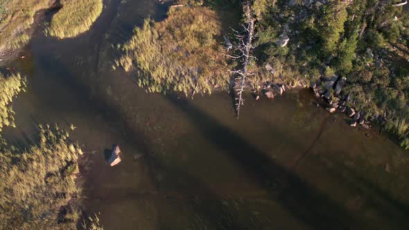 Flying backwards looking down at lake