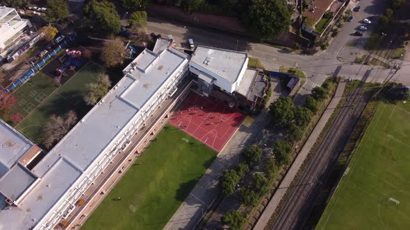 Aerial top down shot of school sports field in Buenos Aires during sunny day,4K - Soccer and Basketb