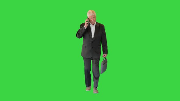Senior Businessman Walking and Making a Call on a Green Screen Chroma Key