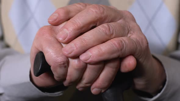 Aged Male Hands on Walking Stick Close-Up, Social Pension Reforms, Health Care
