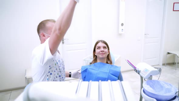 Male doctor is preparing to treat patient's teeth in modern dental clinic. Health teeth concept. 