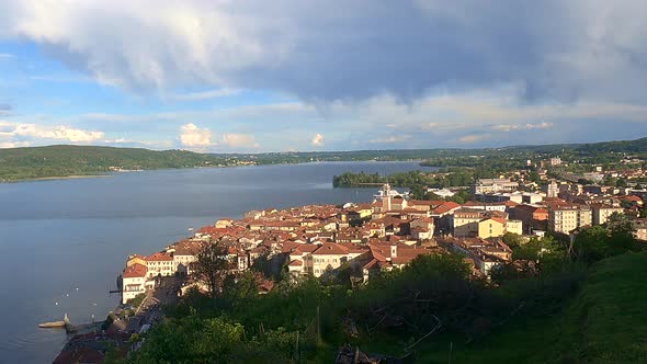 Beautiful wide-angle timelapse ofing clouds over Arona city and Maggiore lake in Italy