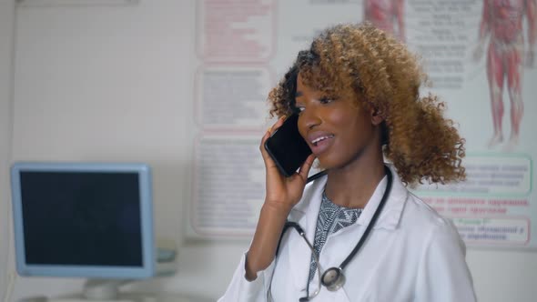 African American Nurse Talking on the Phone in a Modern Hospital. Concept of Medicine, Health Care