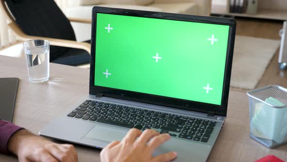 Top View of Man in His House Working on a Laptop with a Green Screen Chroma Mock Up