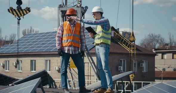 Engineer and Technician Discussing Between Solar Panels