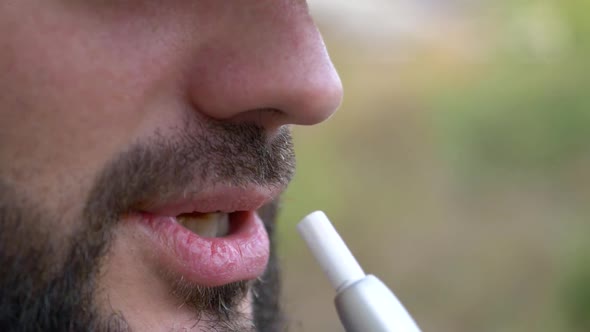 The Bearded Man Smokes an Electronic Cigarette