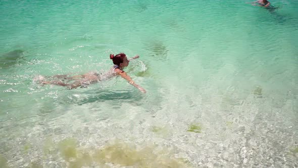 Slim Woman in Swimsuit Swims in a Clear Sea on Sunny Day Summer Vacation Concept