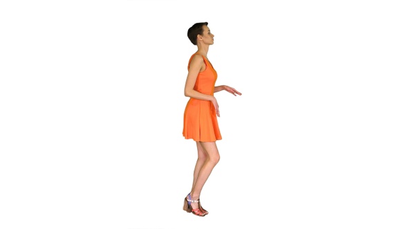 Beautiful Woman Dances in Flirty Orange Dress on White Background