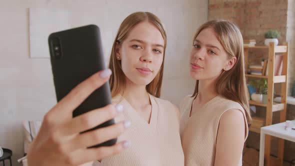 Laughing Twin Sisters Taking Selfie on Mobile Phone