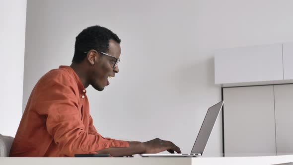 AfricanAmerican Man Gets Surprised Working on Laptop