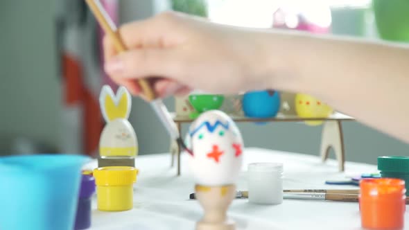 Woman Drawing Patterns on the Easter Egg