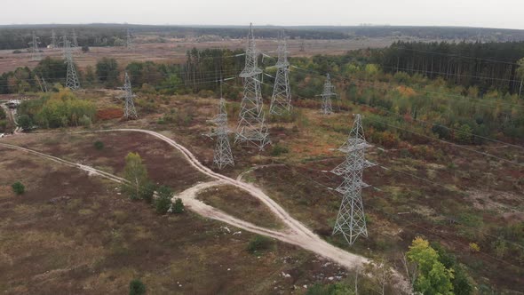 Long distance transmission lines. High-voltage pillars in forest. Power transmission pylons