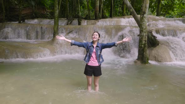 Young Woman Enjoying With  Waterfall