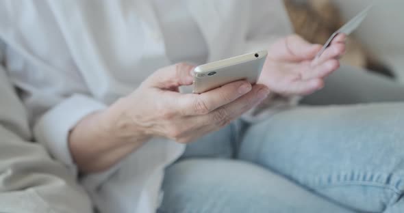 Closeup of an Elderly Woman Shopping on the Internet and Making Online Purchases