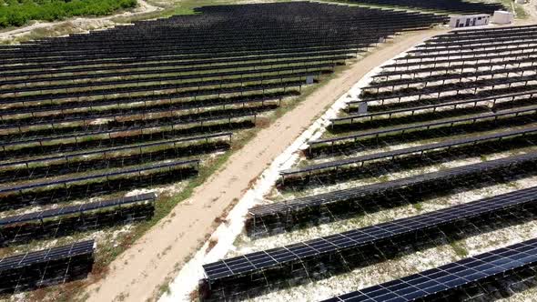 Solar panels farm aerial view from drone shot while sun setting. Small photovoltaic cell panels