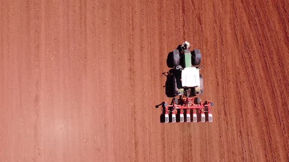 Farmer Seeding, Sowing Crops at Field with Tractor. Sowing Is the Process of Planting Seeds in the