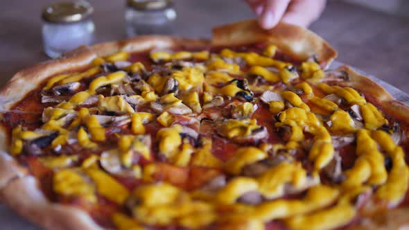 Close Up of Hand Taking Delicious Slice of Pizza Off a Wooden Tray